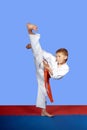 Training strike yoko-geri athlete in white karategi