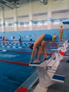 Training swimmers. A teenage boy is preparing to jump into the pool. Sport is a way of life. Health, good figure and Royalty Free Stock Photo