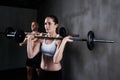 Training to become fighting fit. two people lifting barbells during a gym workout.