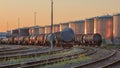 Trains with silos of a petrochemical plant on the background lit by warm light, Port of Antwerp, belgium Royalty Free Stock Photo