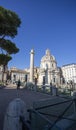 Trajan column in Rome seen from the path under the trees behind it. Daytime