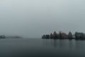 Trakai Island Castle - turreted castle on a tranquil island connected by footbridge with a Lithuanian culture museum during foggy