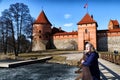 Island castle in Trakai and tourist near it. One of the most popular touristic destinations in Lithuania in early spring Royalty Free Stock Photo