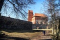 Island castle in Trakai and tourist near it. One of the most popular touristic destinations in Lithuania in early spring Royalty Free Stock Photo