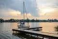 Trakai, Lithuania - August 15, 2017: Beautiful evening summer landscape of Trakai lake and little sport yacht near wooden pier.