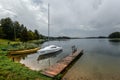 Trakai, Lithuania - August 15, 2017: Beautiful evening summer landscape of Trakai lake and little sport yacht near wooden pier.