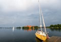 Little yellow sport yacht on the lake Trakai, Lithuania.