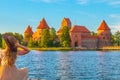 TRAKAI/LITHUANIA: 09/07/2019: Beautiful girl sitting in front of the colorful Trakai Historical National Park, UNESCO world