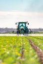 Traktor during spraying chemicals in the field.