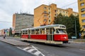 Tram is crossing concrete building blocks built during the communist era