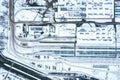 Tram depot in winter foggy day. urban industrial district with snow-covered buildings. aerial drone photo
