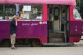 Tram driver in front of a Kosice tram, Tatra T3 model, at a tram stop.