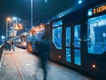 The tram leaves the stop in night city, motion blur view