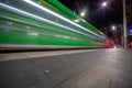 Tram moving through George St at night leaving colourful light trails Sydney