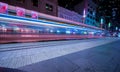 Tram moving through George St at night leaving colourful light trails Sydney