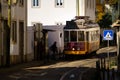 Tram 28 at the tram stop on the street Rua das Escolas Gerais in Lisbon, Portugal.