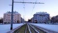 Tram track going between two buildings during winter evening.