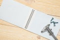 Trammel and screw with empty notebook Royalty Free Stock Photo
