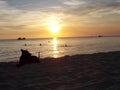 tramonto con barca e cane sulla sabbia