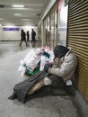 A tramp, a beggar, a homeless man is warming himself and sleeping.