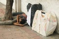 The tramp lying on the sidewalk.