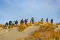 Tramping group on Sand dunes and surf waves in bay