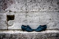 Trampled discarded shoes against the background of a limestone wall. Still life Royalty Free Stock Photo