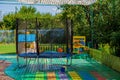 Trampoline on the playground for children. A cozy corner in the yard for children`s games