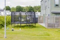 Trampoline with safety net mounted on backyards with  football balls. Outdoor activity concept. Royalty Free Stock Photo