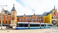 Trams coming and going at the historic Centraal Station building of the main train station in the center of Amsterdam Royalty Free Stock Photo