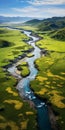 Tranquil Aerial View Of A River Flowing Through A Green Field