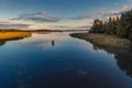 Tranquil aerial view of two fishermen fishing from a boat at sunset on a river in Northern Europe. On the right of the