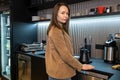 Tranquil barista posing for the camera in her working place