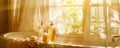 A tranquil bathroom scene with soap and shower gel bottles on a bathtub, sunlight streaming through