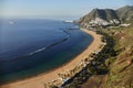 Tranquil beach curves along a coastal town with mountains in the background, captured at sunrise Royalty Free Stock Photo