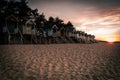 there are some colorful beach huts on the beach by the trees Royalty Free Stock Photo