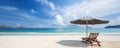 beach chairs and an umbrella on a white sand beach with a breathtaking blue sky Royalty Free Stock Photo