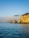 the cliffs near the beach are in low lying fogs