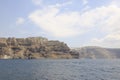 Tranquil blue sea, with a towering rock formation in the background