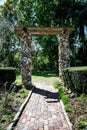 Tranquil brick pathway lined with lush foliage leads to a picturesque park