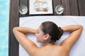 Tranquil brunette lying on towel poolside with beauty treatments Royalty Free Stock Photo