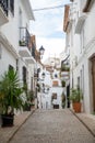 Tranquil cobblestone street with white buildings in Altea, Spain.