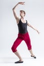 Tranquil Concentrated Contemporary Ballet Dancer Flexible Athletic Man Posing in Red Tights in Ballanced Dance Pose on White