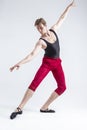 Tranquil Concentrated Contemporary Ballet Dancer Flexible Athletic Man Posing in Red Tights in Ballanced Dance Pose on White