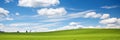 Tranquil countryside panorama with lush green fields, freshly cut grass, and a serene blue sky