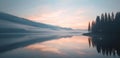 Tranquil dawn breaks over a misty lake surrounded by forested mountains, casting a soft glow on the serene waters. Royalty Free Stock Photo