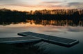 Tranquil dock situated on a still lake in the evening, at sunset Royalty Free Stock Photo