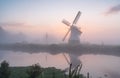 A tranquil, foggy dawn at a windmill.