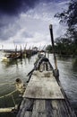 Tranquil image at wooden jetty with dark clouds.