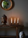 Tranquil Interior Scene Featuring Buddha Head Candles and Rustic Console Royalty Free Stock Photo